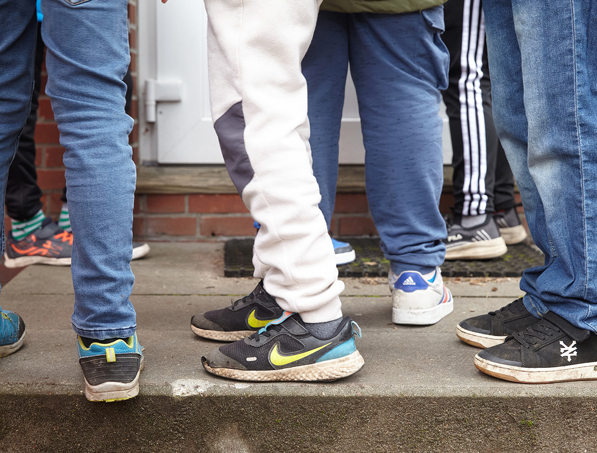 Beine mit Turnschuhen stehen auf einer Stufe