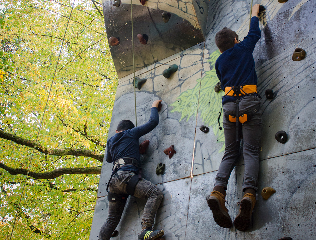 Jungen klettern eine Kletterwand hoch